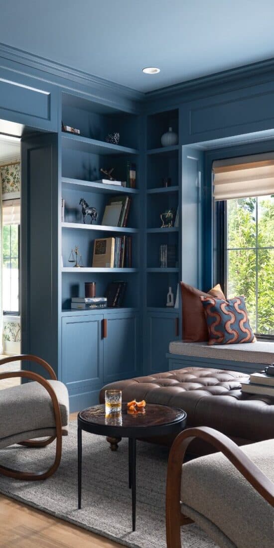 Blue home library with custom built-ins, window seat and tailored furnishings in a Glenview, Illinois home by Stojakovic Design